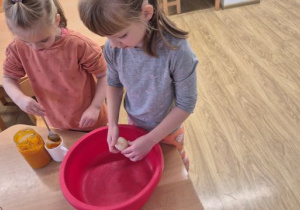 Dziewczynki przygotowują składniki na dyniowe babeczki.