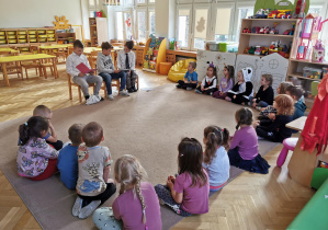 Wolontariusze czytają książkę dzieciom