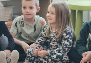 Wolontariusze czytają książkę dzieciom