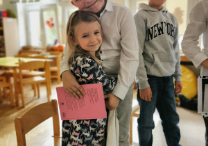 Wolontariusze czytają książkę dzieciom