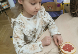 dziecko wykonuje ozdobę na choinkę