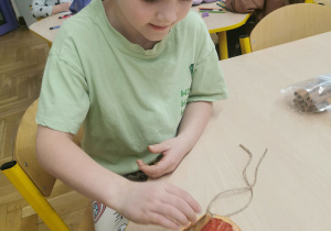 dziecko wykonuje ozdobę na choinkę