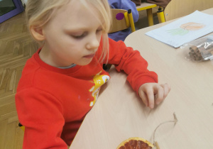 dziecko wykonuje ozdobę na choinkę