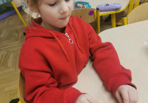 dziecko wykonuje ozdobę na choinkę