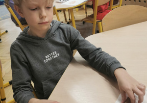 dziecko wykonuje ozdobę na choinkę