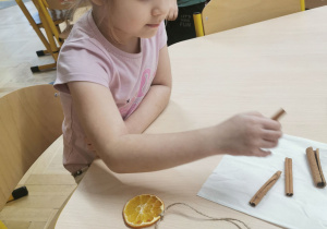 dziecko wykonuje ozdobę na choinkę