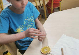 dziecko wykonuje ozdobę na choinkę