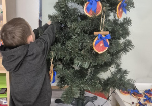 dziecko ubiera choinkę