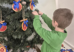 dziecko ubiera choinkę