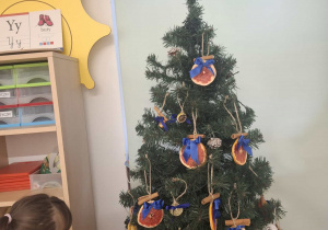 dziecko ubiera choinkę