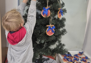 dziecko ubiera choinkę