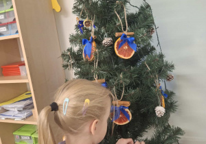 dziecko ubiera choinkę