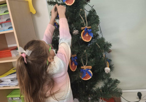 dziecko ubiera choinkę