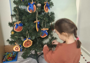 dziecko ubiera choinkę