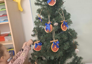 dziecko ubiera choinkę