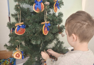 dziecko ubiera choinkę
