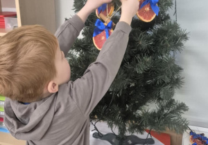 dziecko ubiera choinkę