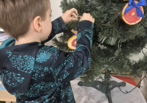 dziecko ubiera choinkę