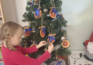 dziecko ubiera choinkę