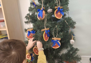 dziecko ubiera choinkę