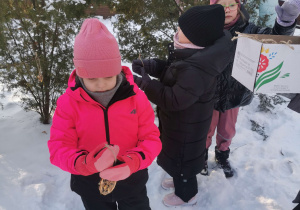 dzieci dokarmiają ptaki zimą
