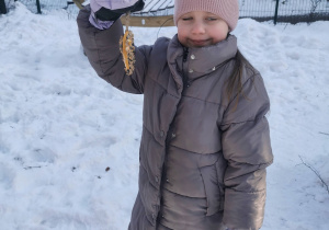 dzieci dokarmiają ptaki zimą