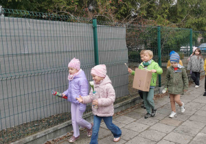 dzieci grają i śpiewają na spacerze wiosennym