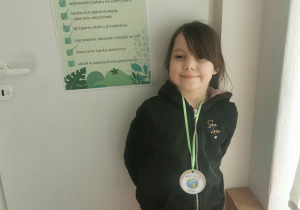 dziewczynka z medalem i plakatem ekomisji