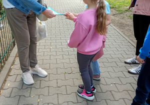 dzieci rozdają podczas spaceru karteczki niezapominajkowe