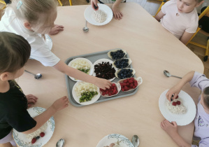 dzieci wybierają dodatki do swojej owsianki