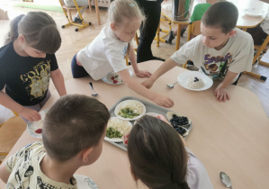 dzieci wybierają dodatki do swojej owsianki
