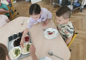 dzieci wybierają dodatki do swojej owsianki