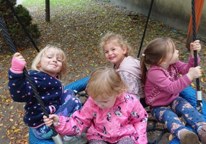 Dzieci siedzą na huśtawce