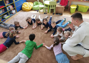Uśmiechnięte dzieci ćwiczą na dywanie 8