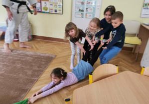 Uśmiechnięte dzieci ćwiczą na dywanie 15