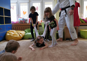 Uśmiechnięte dzieci ćwiczą na dywanie 17