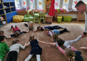 Uśmiechnięte dzieci ćwiczą na dywanie 19