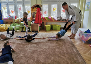 Uśmiechnięte dzieci ćwiczą na dywanie 21