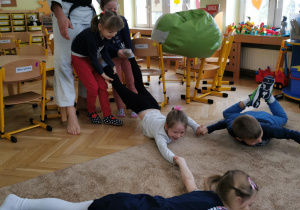Uśmiechnięte dzieci ćwiczą na dywanie 24