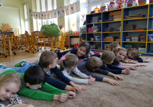 Uśmiechnięte dzieci ćwiczą na dywanie 34