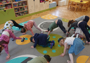 Dzieci robią na dywanie kocie grzbiety