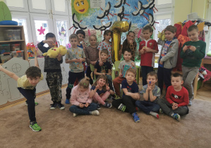 zdjęcie grupowe, na środku dwaj jubilaci i złoty balon z helem, po bokach wszystkie dzieci