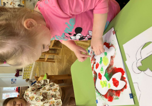 Dziewczynka stempluje szablon zajączka folią umoczoną w farbie