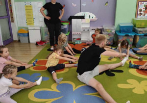 Dzieci ćwiczą z instruktorem