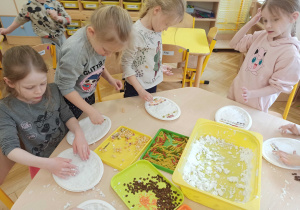 dzieci układają kolorowy makaron w masie plastycznej