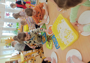 dzieci układają kolorowy makaron w masie plastycznej