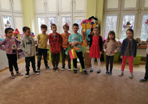 dzieci stoją na dywanie i śpiewają piosenkę urodzinową, na środku stoi jubilat