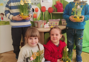 Dzieci pozują do zdjęcia z trawką Wielkanocną.