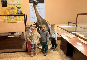 Dzieci fotografują się z eksponatami dinozaurów