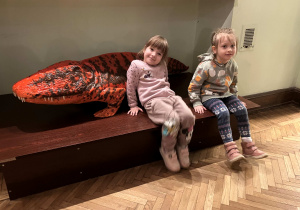 Dzieci fotografują się z eksponatami dinozaurów